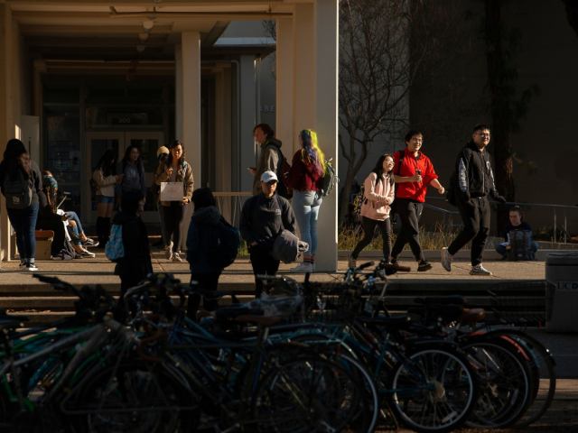 students walking around bike racks near Young Hall