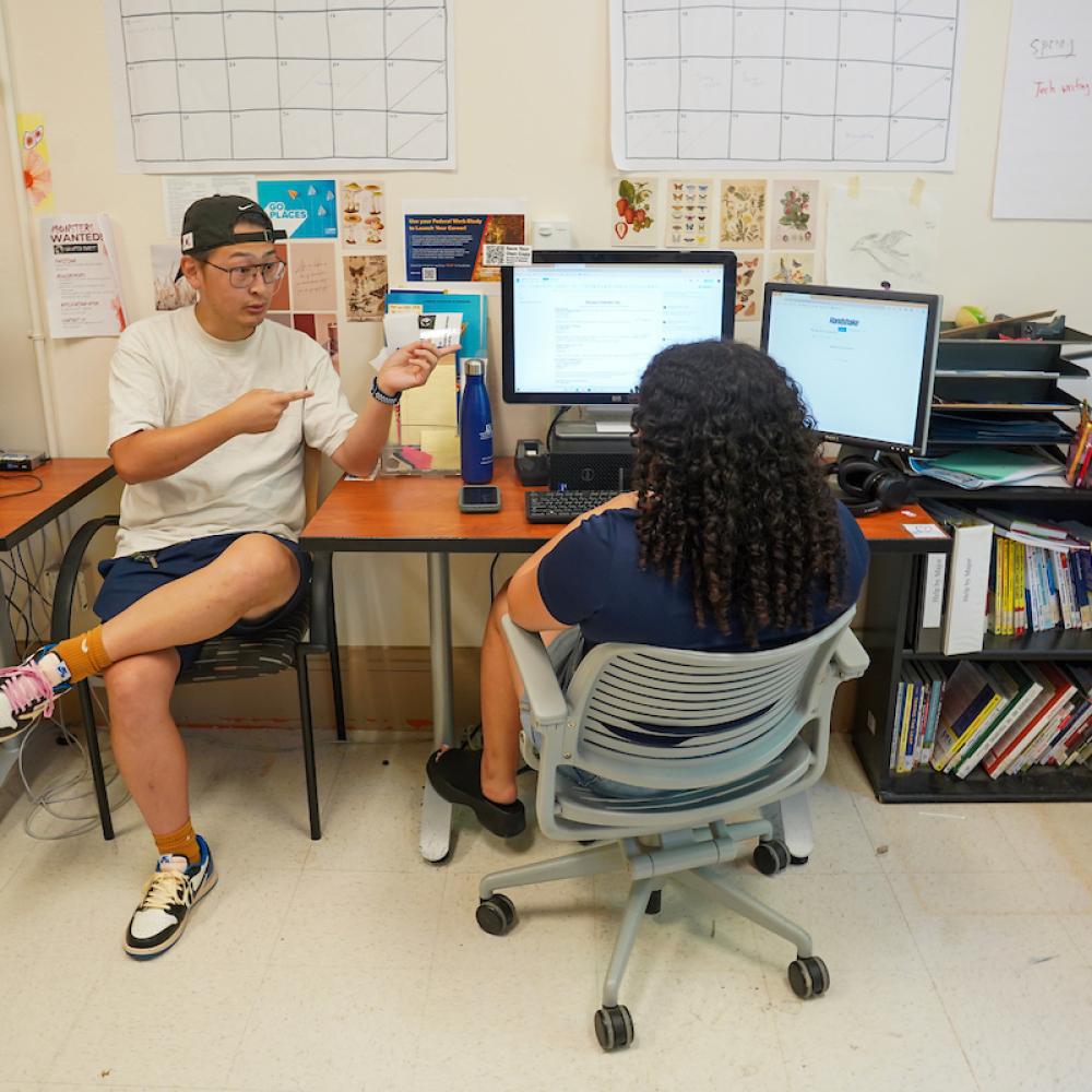 Two people chatting at a desk