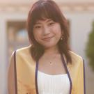Staff photo: upper body shot of Portia Luong, wearing a white top and gold graduation stole